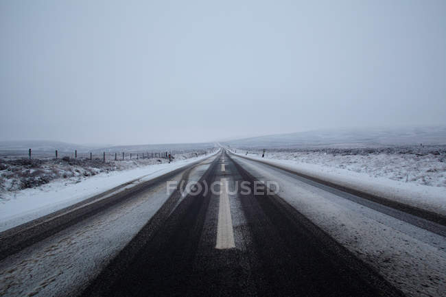 Vista de estrada de asfalto e montanhas na neve — Fotografia de Stock