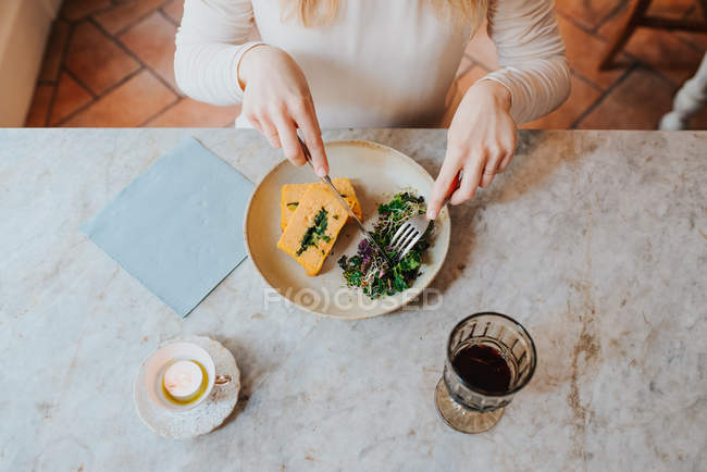 Женщина ест веганскую еду в ресторане — стоковое фото