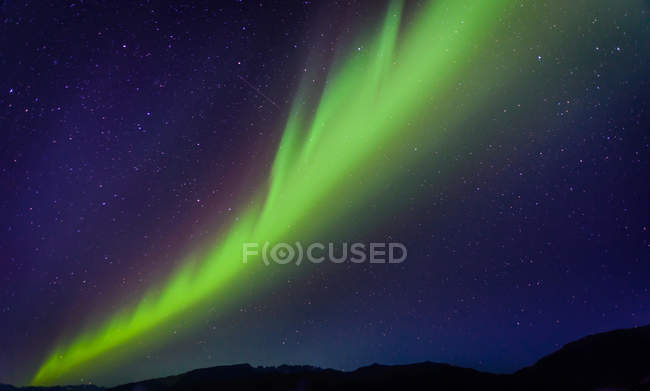 Aurora Borealis sobre cordillera, Narsaq, Vestgronland, Groenlandia - foto de stock