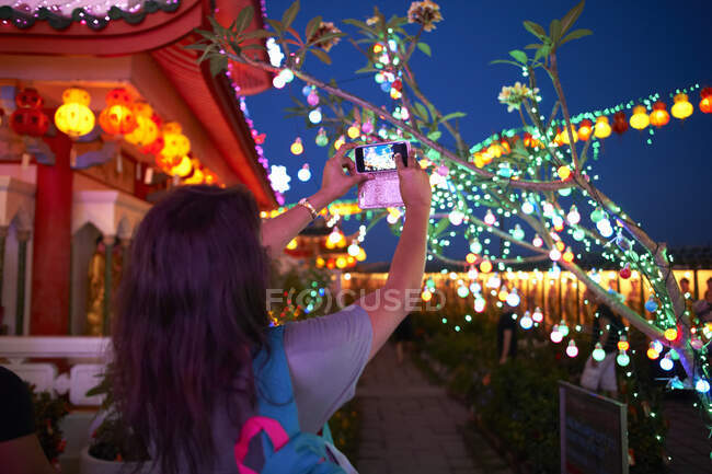 Turista tomando fotografías de decoraciones ligeras, Templo Kek Lok Si, Isla Penang, Malasia - foto de stock