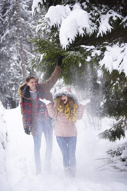 Молодая пара играет в снегу — стоковое фото