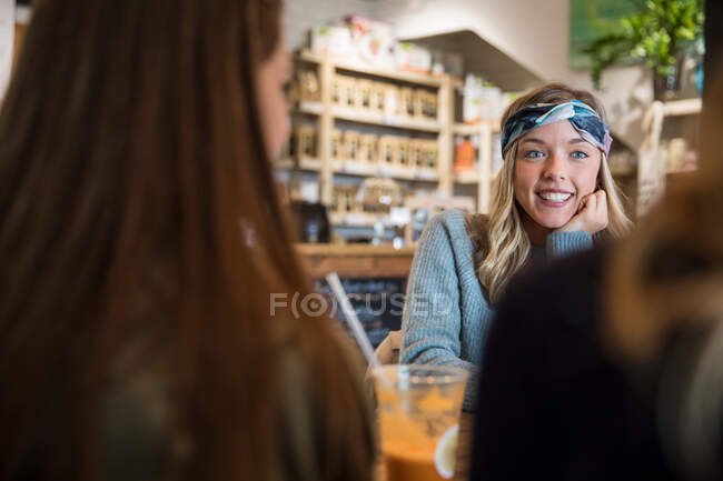 Three female friends, sitting in cafe, catching up, drinking smoothies — Stock Photo
