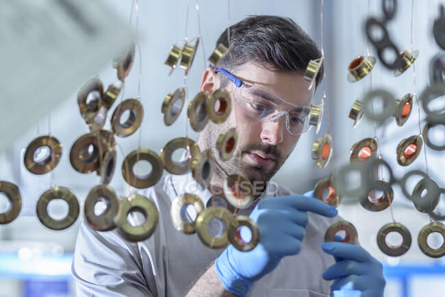 Componentes colgantes listos para ser sumergidos en productos químicos en la fábrica de galvanoplastia - foto de stock
