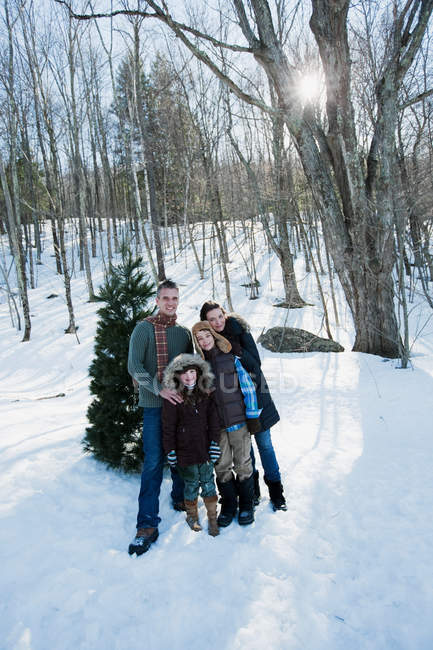 Портрет семьи, стоящей в снежном лесу — стоковое фото