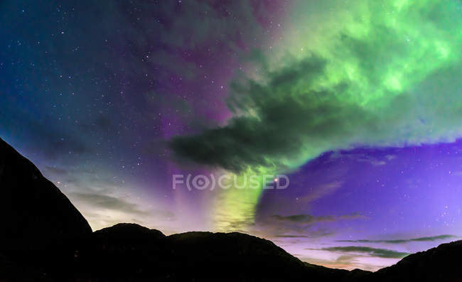 Aurora boreal sobre silueta de montañas, Narsaq, Vestgronland, Groenlandia - foto de stock