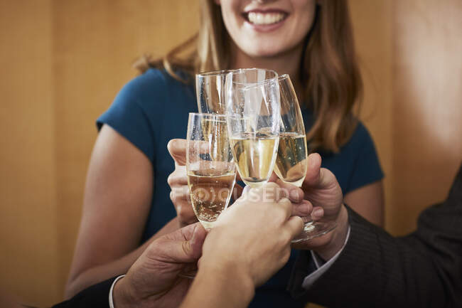 Business team raising champagne toast at office celebration, cropped — Stock Photo