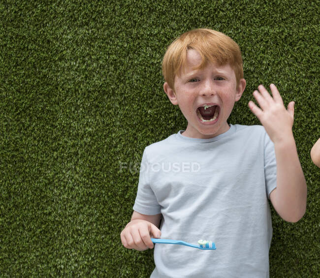 Расстроенный мальчик чистит зубы — стоковое фото