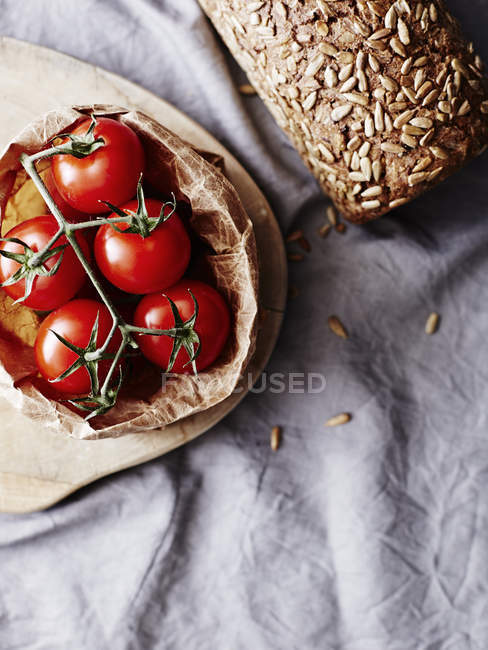 Rye bread with seeds and vine tomatoes — Stock Photo