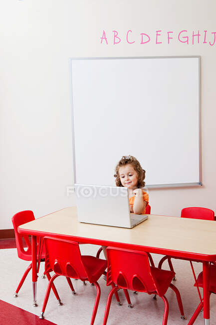 Girl using laptop in classroom — Stock Photo