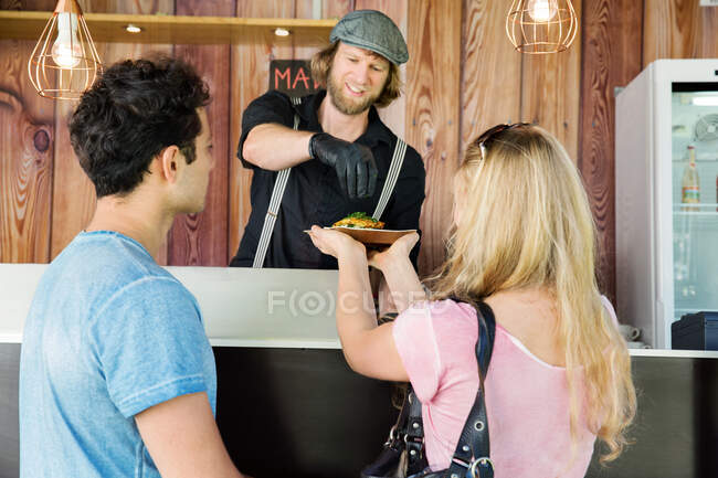 Cook in food truck serving customers — Stock Photo