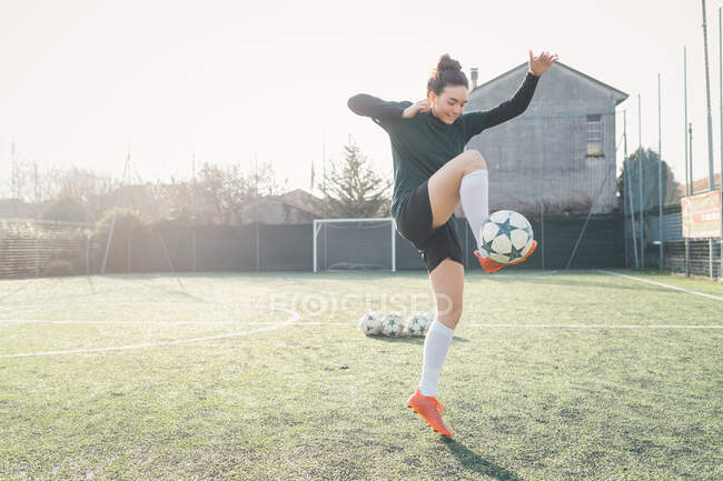 Jugador de fútbol practicando en campo de fútbol - foto de stock