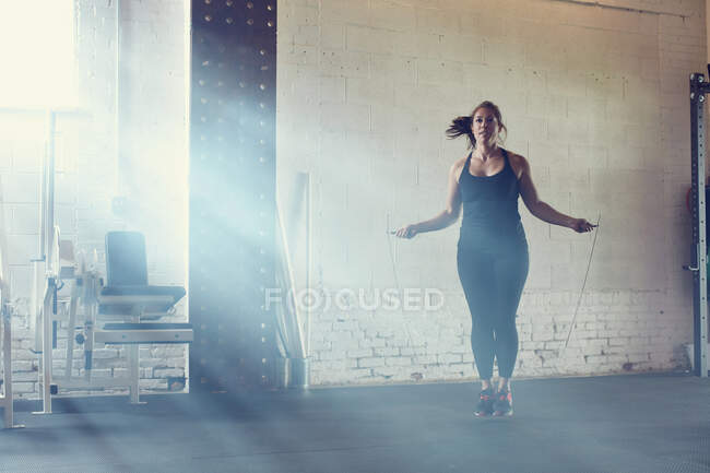 Woman skipping in gym — Stock Photo