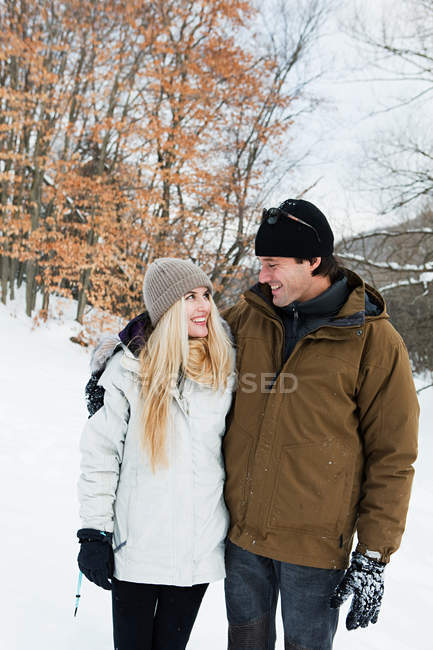 Retrato de pareja sonriente en un paisaje nevado - foto de stock