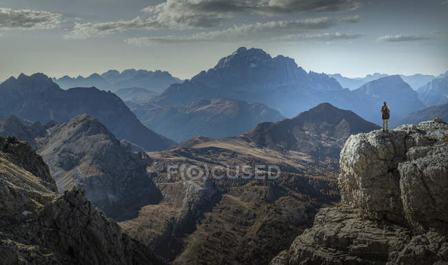 Femelle grimpeuse sur une falaise regardant les chaînes de montagnes, Dolomites, Cortina dAmpezzo, Veneto, Italie — Photo de stock