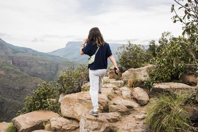 Назад вид молодой женщины турист исследуя Три Rondavels, Мпумаланга, Южная Африка — стоковое фото