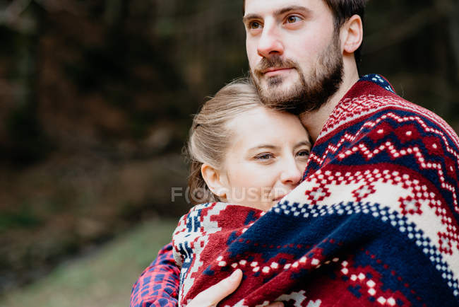 Retrato de casal envolto em cobertor ao ar livre — Fotografia de Stock