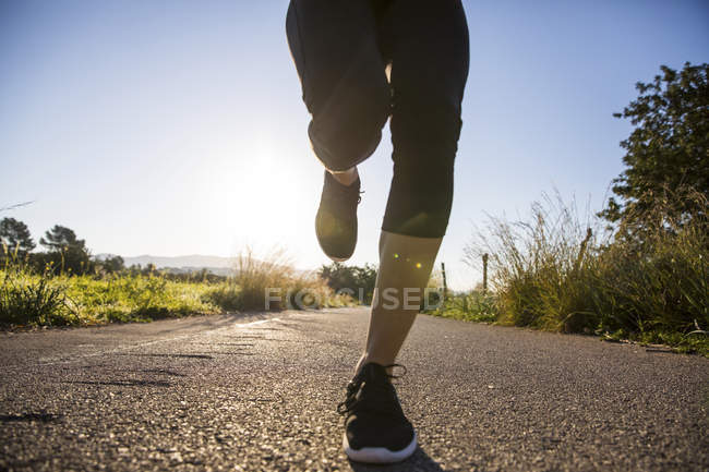 Low section of young woman running outdoors — Stock Photo