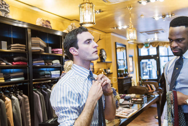 Customer fastening tie in tailor shop — Stock Photo