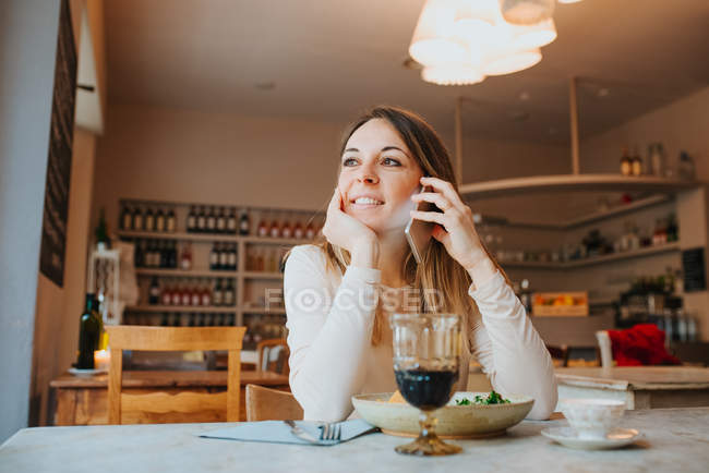 Donna che parla al telefono e sorride al ristorante — Foto stock