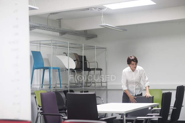 Young female sale manager near chairs in office furniture store — Stock Photo