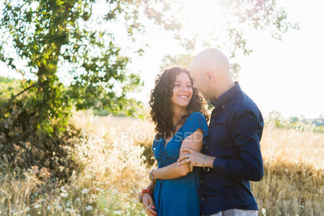 Portrait of couple hugging in field — Stock Photo