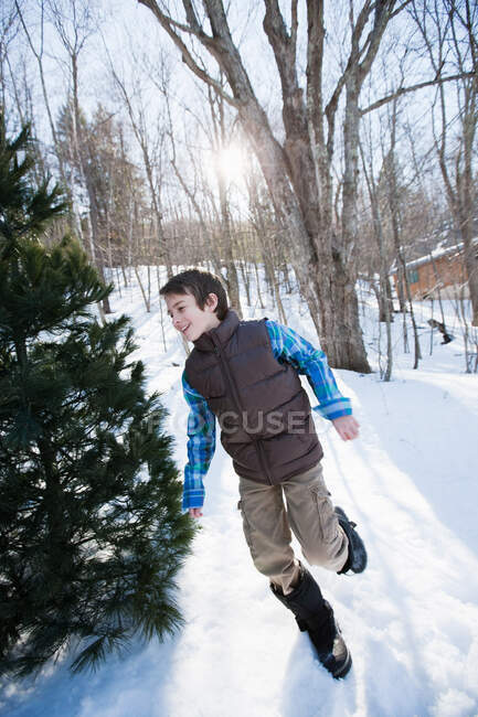 Хлопчик біжить снігом — стокове фото