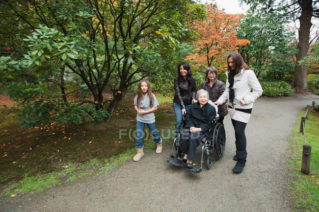 Семья из нескольких поколений с пожилой женщиной в инвалидной коляске — стоковое фото
