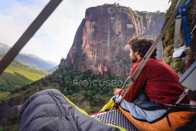 Rock climber on portaledge, looking at view, Liming, Yunnan Province, China — Stock Photo