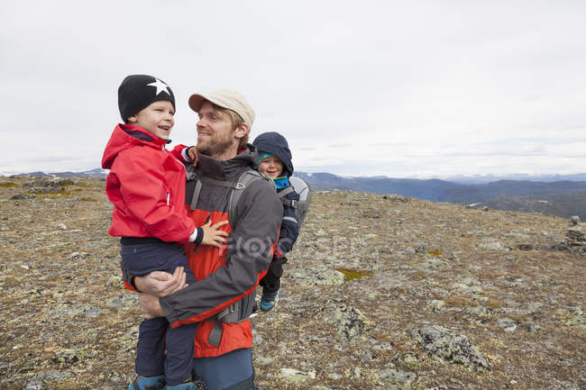 Escursionista maschio con figli nel paesaggio montano, Parco nazionale di Jotunheimen, Lom, Oppland, Norvegia — Foto stock