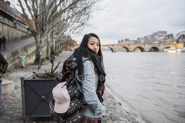 Vista lateral de Retrato de joven turista por el río Sena, París, Francia - foto de stock
