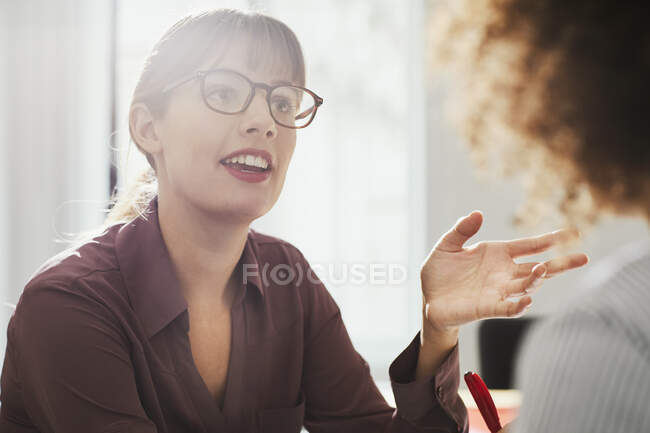 Businesswoman in office talking to colleague — Stock Photo