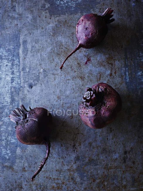Still life of three raw beetroots, overhead view — Stock Photo