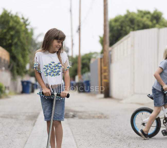Little Girl in lane with scooter on street — Stock Photo