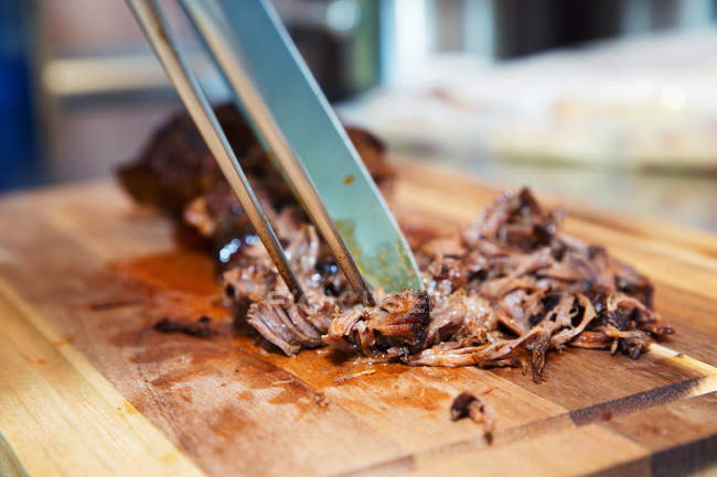 Pulled pork on wooden board, close-up — Stock Photo