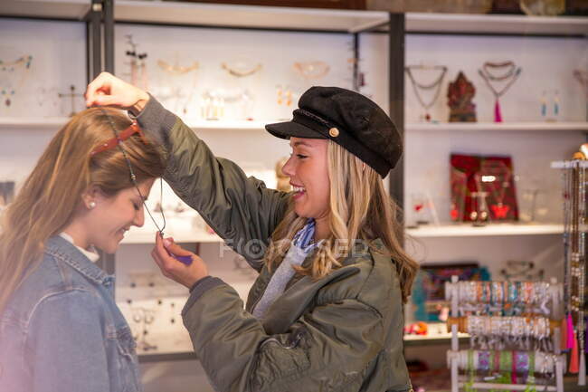Duas amigas, às compras, a experimentar um colar — Fotografia de Stock