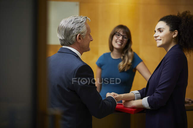 Femme d'affaires et homme serrant la main à la réception — Photo de stock