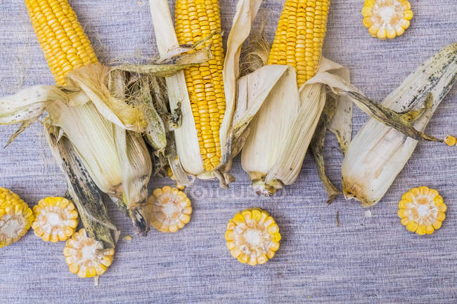 Corn on the cob with slices of corn, overhead view — Stock Photo
