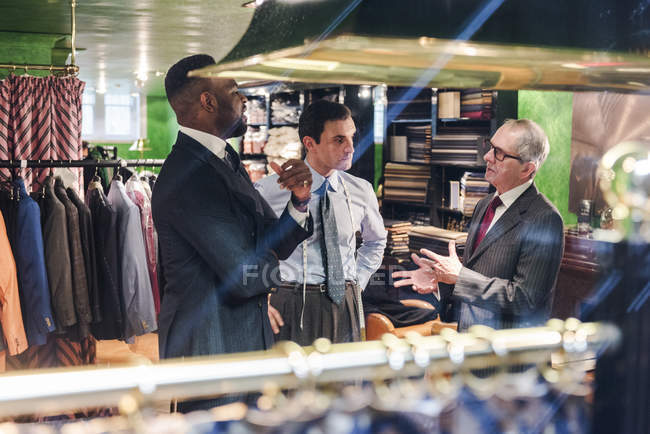Alfaiates e cliente tendo discussão na loja tradicional alfaiate — Fotografia de Stock