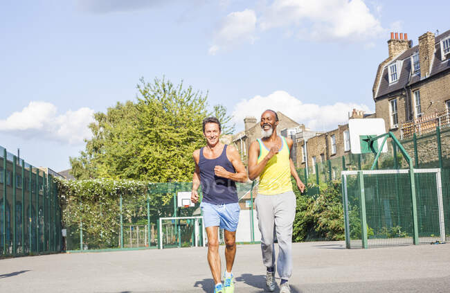Dois homens maduros, ao ar livre, correndo — Fotografia de Stock