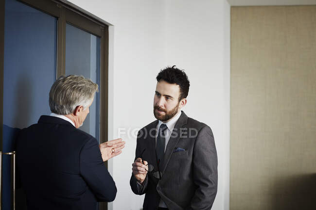 Старший бизнесмен беседует с коллегой-мужчиной в офисе — стоковое фото