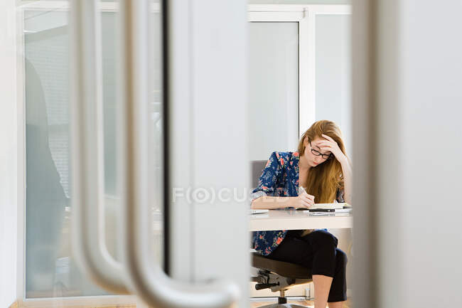 Junge Modedesignerin arbeitet am Schreibtisch — Stockfoto