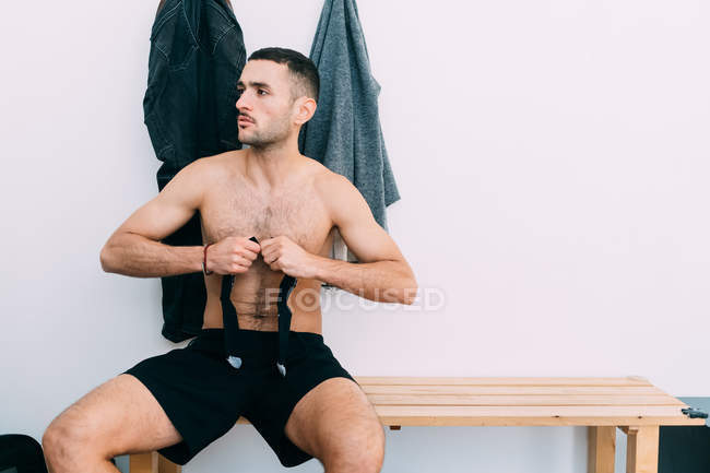 Man on bench in changing room looking away — Stock Photo