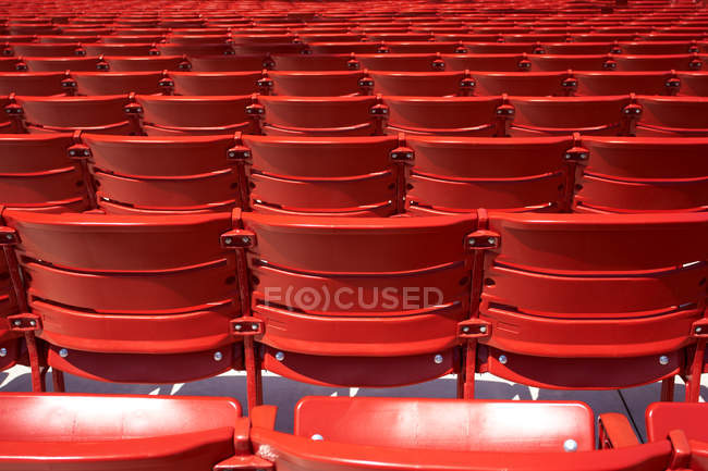 Vista de las sillas rojas del estadio en fila - foto de stock