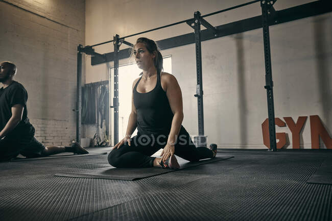 Mujer en posición de yoga en gimnasio - foto de stock