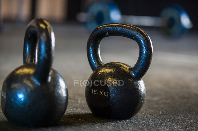 Kettlebells on gymnasium floor, close-up — Stock Photo