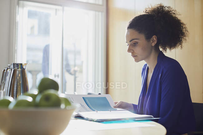Young businesswoman reading paperwork at office desk — Stock Photo