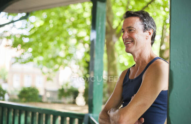 Maturo uomo in piedi sotto bandstand, sorridente — Foto stock