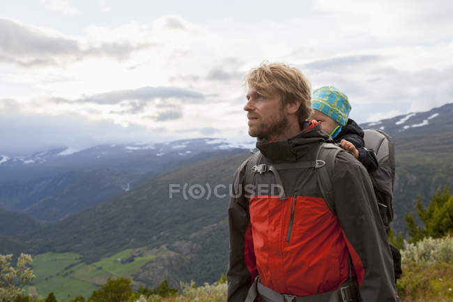 Escursionista maschio con figlio nel paesaggio montano, Parco nazionale di Jotunheimen, Lom, Oppland, Norvegia — Foto stock