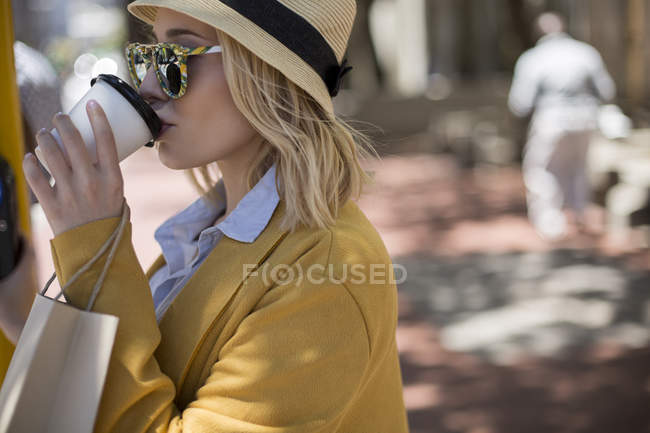 Mulher bebendo café em copo descartável ao ar livre — Fotografia de Stock