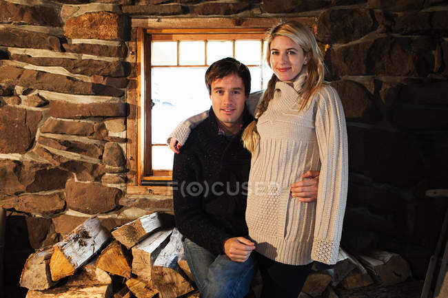 Retrato de casal sorrindo para a câmera na casa rústica — Fotografia de Stock